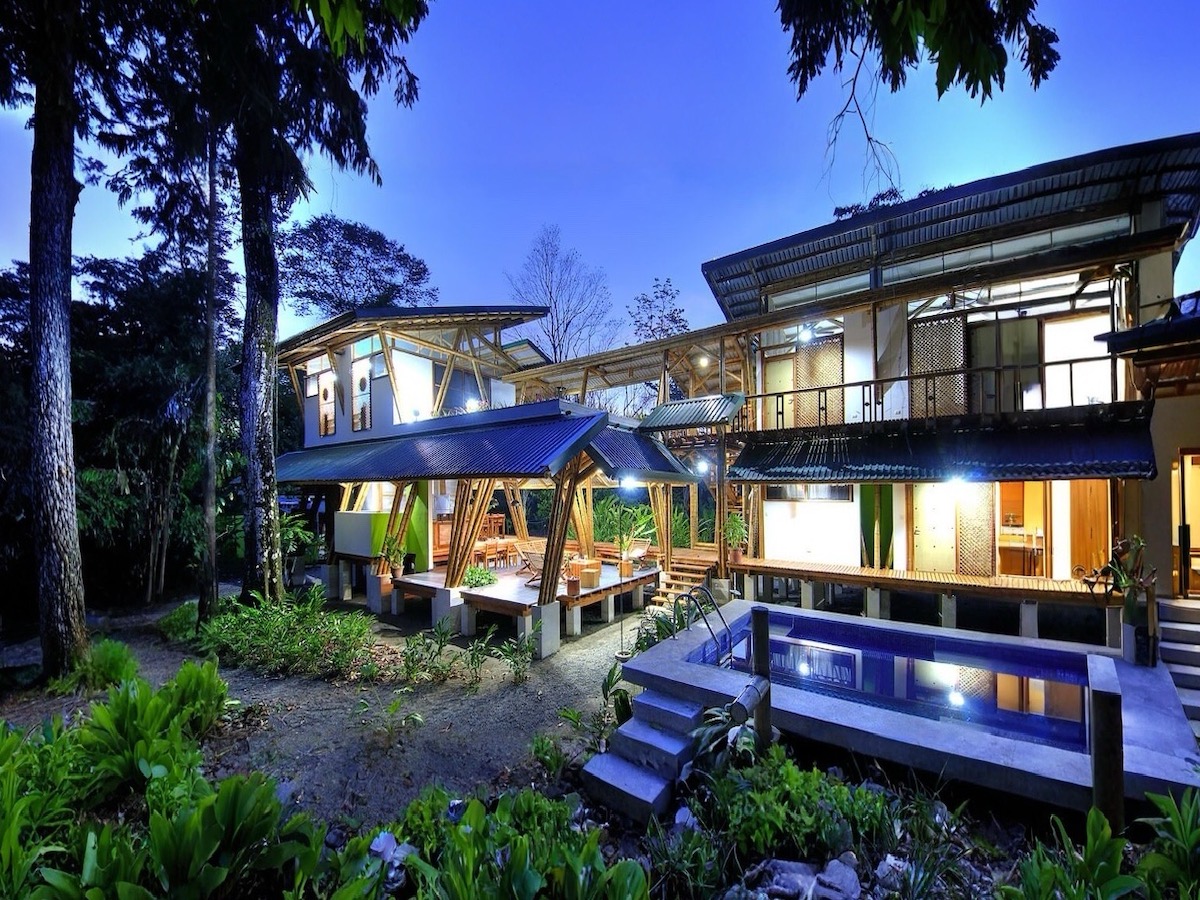 |Howler monkeys above bamboo lodge|Artistic bamboo roof design on Costa Rica beachfront home|Luxury bamboo villa on beachfront property near Puerto Jiménez|Secluded beachfront entry surrounded by rainforest|Sunlit tropical interior with wooden finishes |Solar energy and water system infrastructure near eco-lodge |Tropical-style storage structure near beachfront lodge |Beachfront villa overlooking calm waters of Golfo Dulce|Bamboo and wood architecture at boutique eco-hotel |Swimming pool near beach with tropical palm trees|Caretaker home amidst lush vegetation in Osa Peninsula |Wooden and bamboo decor inside eco-lodge room |Bedroom overlooking tropical flora in Puerto Jiménez|Bathroom with bamboo walls and modern fixtures |Communal space in eco-lodge with tropical decor|Outdoor dining area with tropical garden backdrop|Laundry and service room within bamboo lodge|Spacious bamboo kitchen with dining area|Dining area with wood furnishings and garden view|Cozy tropical seating area with natural accents|Open-concept living room with bamboo architecture|Bamboo ceiling detail of luxury beachfront lodge|Living room opens directly to poolside deck|Handcrafted furniture inside beachfront home Puerto Jiménez |Yoga deck facing ocean at eco-lodge |Living area with views of pool and gardens |Interior view of eco-lodge with open walls and garden access |Macaws flying over beachfront lodge Osa Peninsula|Bamboo pillars and hardwood beams in Costa Rica villa | Caretaker residence on tropical beachfront property in Puerto Jiménez |Hammock between palms at beachfront property|Pathway from retreat to jungle beach|Eco-luxury beachfront lifestyle in Puerto Jiménez