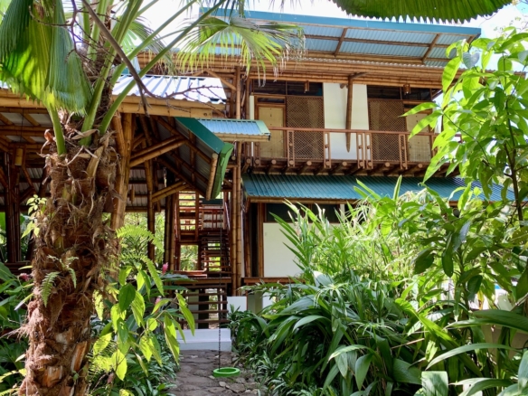 Interior view of eco-lodge with open walls and garden access 