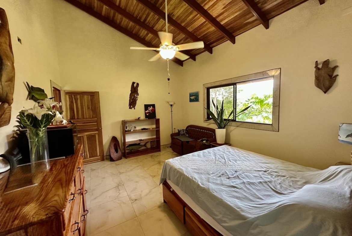 Tropical-style bedroom with large windows and forest views in Osa Peninsula property.