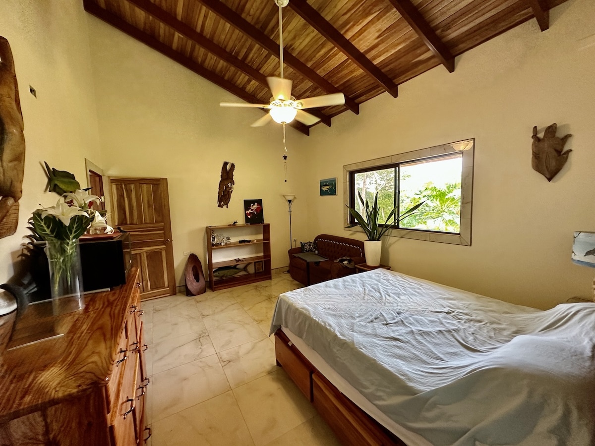 Tropical-style bedroom with large windows and forest views in Osa Peninsula property.